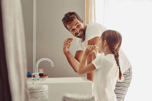 A Man Brushing Teeth With Daughter